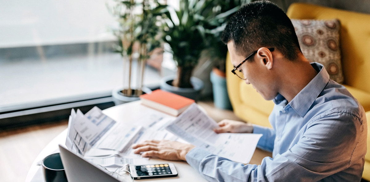 Financial adviser reviewing product fees and prices at his home office.